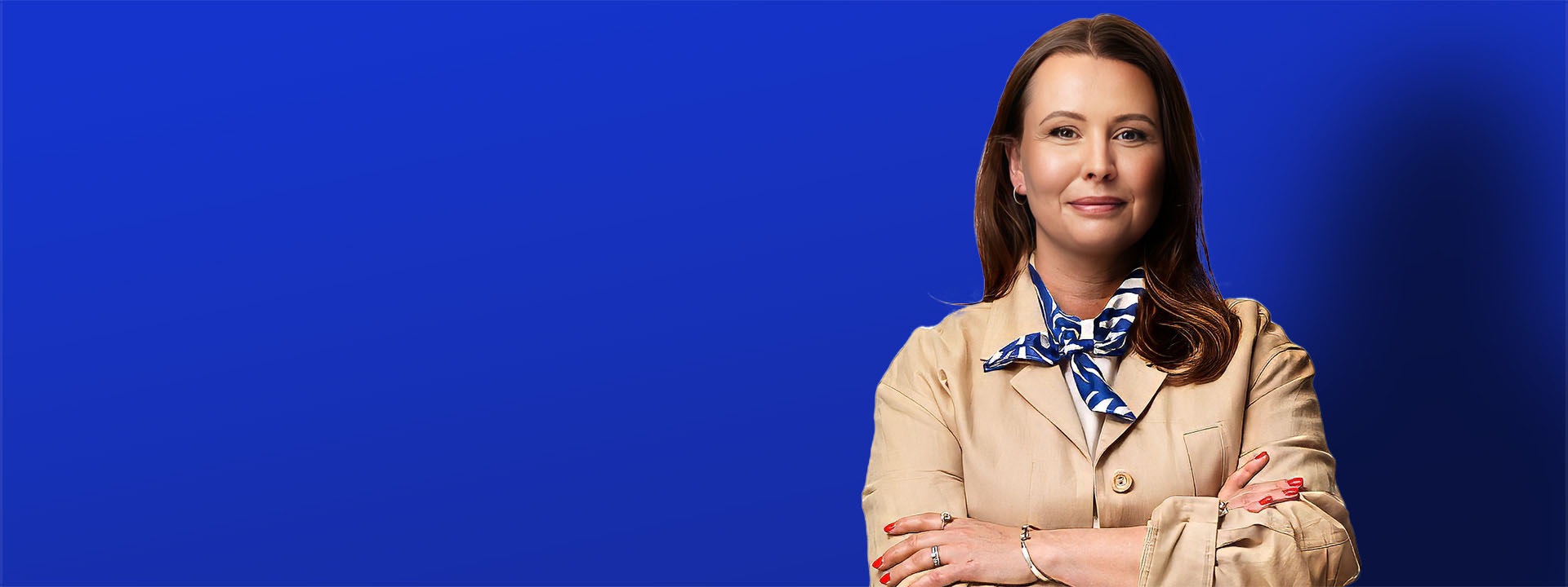 woman standing cross armed in front of blue background