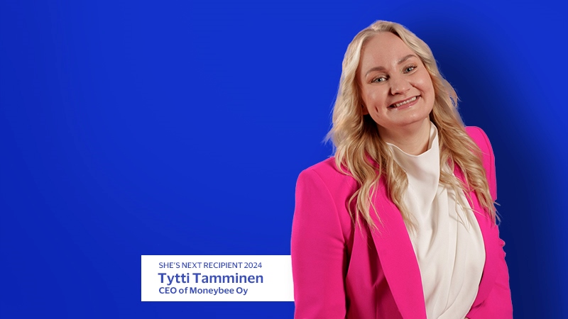 Tytti Tamminen smiling with blue background