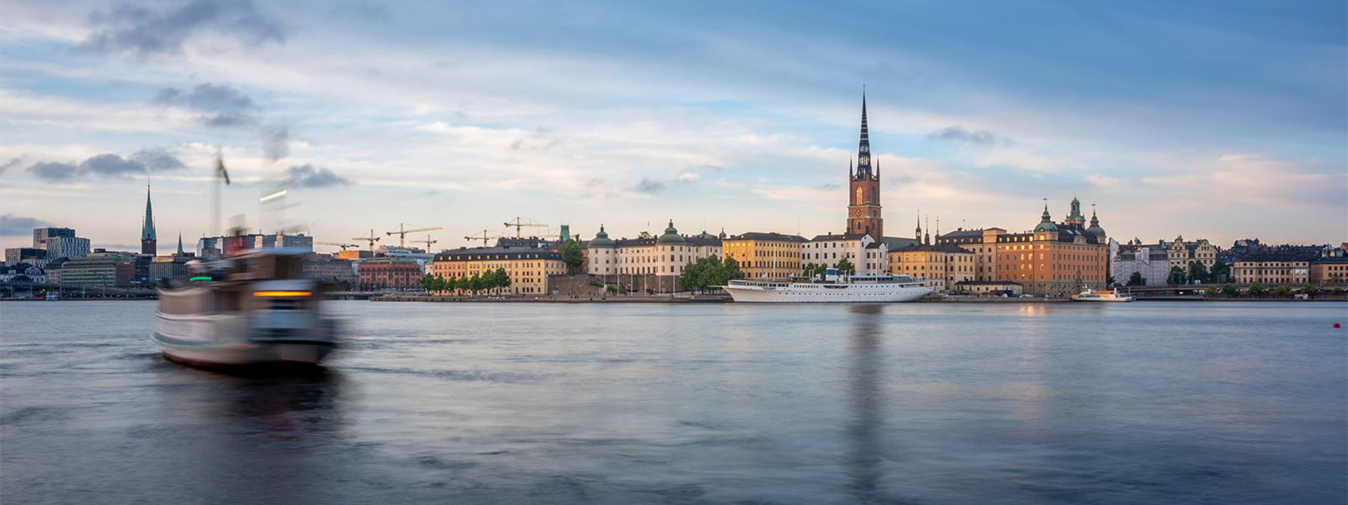 boats on calm river alongside buildings