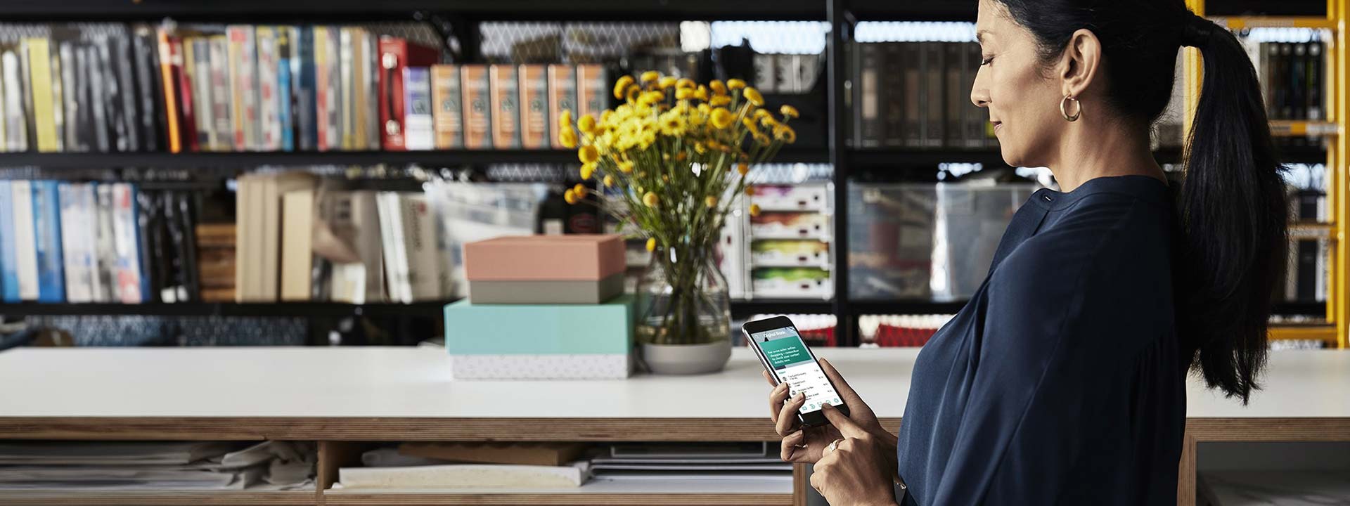 woman using her phone in shop