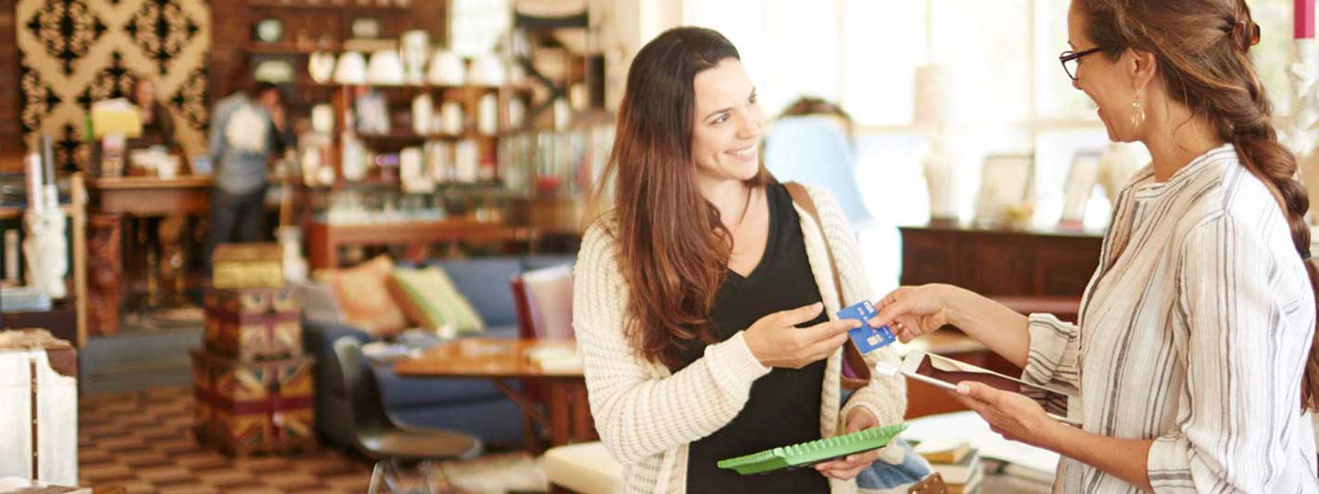 women paying with card in shop