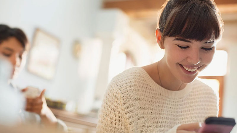 woman smiling at phone