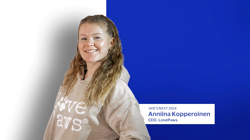 Anniina Kopperoinen smiling and posing with blue and white background