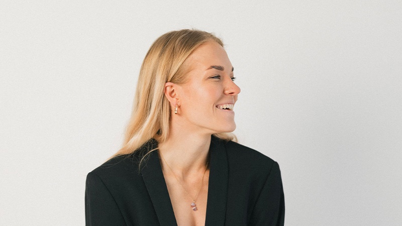 Laura Ahti smiling looking left with white background